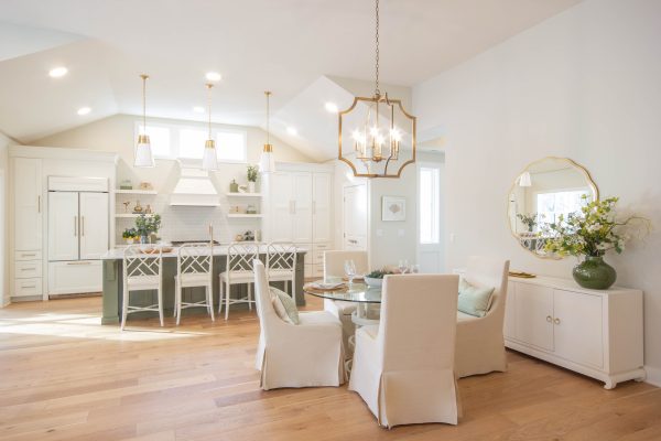 Covington Model view of the Gourmet Kitchen & Dining Room. Three gold pendants hang above an Olive Expanded Island with Quartz Countertops.