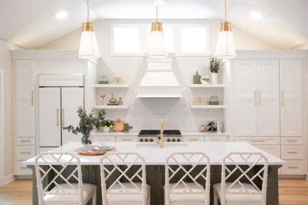 Covington Model view of the Gourmet Kitchen & Dining Room. Three gold pendants hang above an Olive Expanded Island with Quartz Countertops.